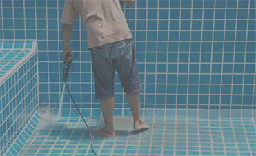 Man cleaning pool tile